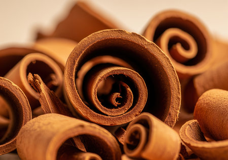 Aromatic cinnamon sticks and shavings piled together in a detailed macro shot, highlighting the rich brown color, spiral shape, and dry texture. essential spice for baking, cooking, and flavor.の素材