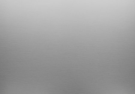 Brushed aluminum metal surface displaying a uniform, subtle horizontal grain texture. minimalist abstract background in a smooth silver gray tone.の素材