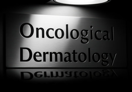 Metallic sign displaying the medical specialization oncological dermatology under dramatic spotlight illumination. monochrome image reflecting seriousness and professionalism in cancer treatment and skin health.の素材
