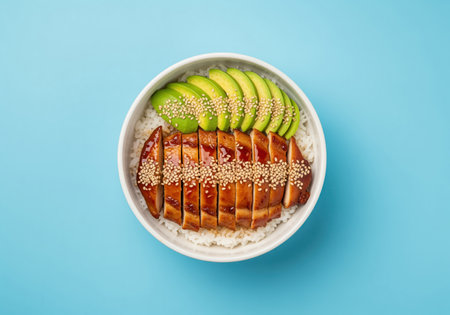 Japanese chicken teriyaki donburi bowl featuring glossy sliced chicken breast glazed with teriyaki sauce, served over white rice, fresh avocado, and sesame seeds.の素材