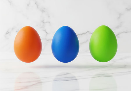 Three brightly colored eggs, orange, blue, and green, floating slightly above a polished white marble surface. clean, minimalist studio shot symbolizing easter, spring, and holiday decoration.の素材