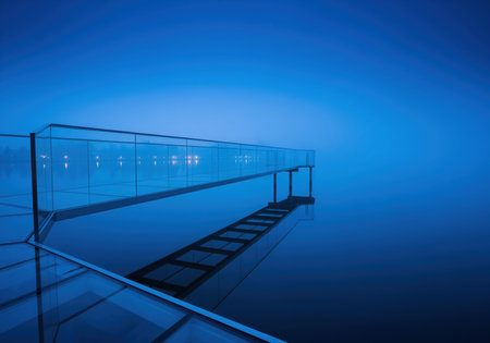 Modern glass walkway extending over a still, misty lake at blue hour. the deep blue tones and reflective water surface create a tranquil and mysterious architectural landscape.の素材