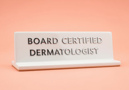 White nameplate sign featuring silver embossed text board certified dermatologist, representing medical professionalism, certification, and skin care expertise.の素材