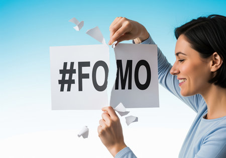 Smiling woman in profile tearing a paper sign displaying the hashtag FOMO, symbolizing breaking free from social media pressure, digital addiction, and anxiety. this represents mental health and digital detox.の素材