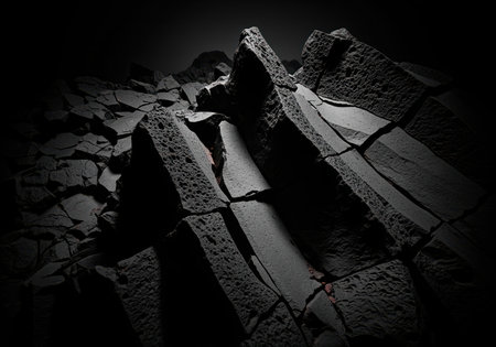 Dark fractured basalt rock structure captured in a dramatically lit, high contrast, low key macro shot. geological texture symbolizing strength, foundation, and darkness.の素材