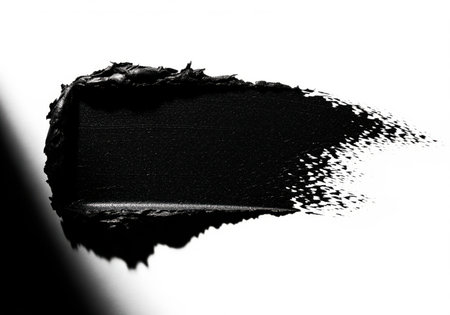 Thick, textured black cosmetic swatch, dramatically lit against a stark white background. high contrast abstract smear perfect for beauty, makeup, or graphic design concepts.の素材