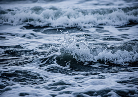 Turbulent ocean waves splashing, featuring detailed white sea foam and spray against dark blue water. close up texture of the powerful, stormy sea.の素材