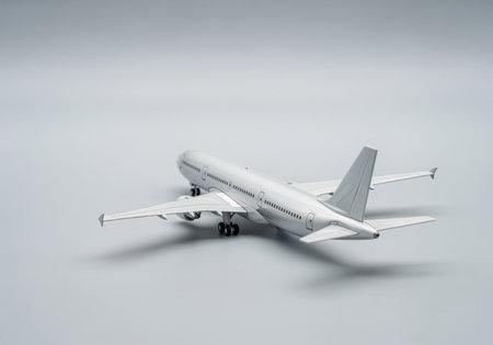 Metallic silver commercial airliner model, ultra sharp and highly detailed, presented on a bright, clean studio surface. represents global travel, aviation, and transport industry.の素材