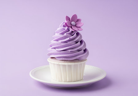 Single purple cupcake with elegant swirl frosting, topped with a delicate flower and sprinkles, presented on a white plate against a soft lavender background. confectionery delight.の素材