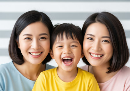 Close up portrait of a happy asian family, featuring two smiling women and a cheerful child laughing brightly, conveying warmth and togetherness.の素材