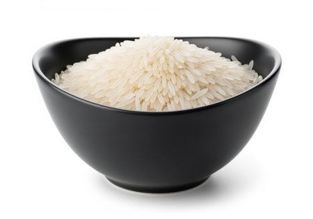 A sleek dark ceramic bowl is filled with dry, uncooked long grain white rice, showcasing its natural texture and pristine appearance. ideal for food blogs or culinary themes.の素材