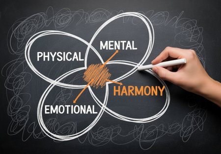 A hand uses chalk to draw a conceptual diagram on a chalkboard, illustrating the interconnectedness of physical, mental, and emotional aspects leading to overall harmony and well being.の素材