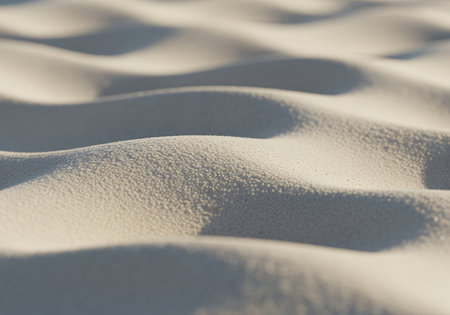 A pristine, hyperrealistic macro photograph captures the delicate, smooth, undulating waves of very pale beige sand, perfect for backgrounds or natural textures.の素材