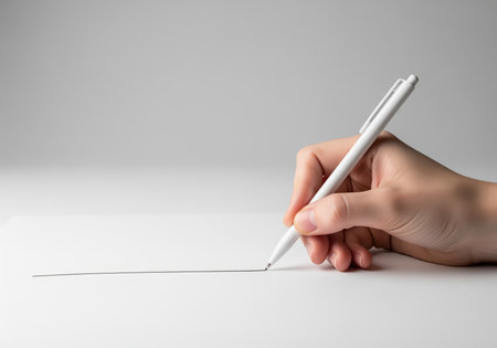 A close up shot of a human hand holding a sleek white pen, drawing a precise straight line on a pristine white surface. this image conveys simplicity and focus.の素材