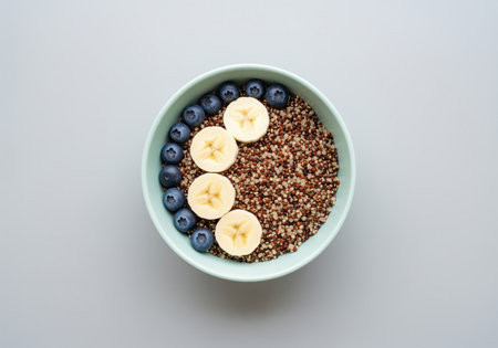 A wholesome tri color quinoa bowl, artfully arranged with fresh blueberries and banana slices, offering a nutritious and delicious meal option. perfect for health conscious content.の素材