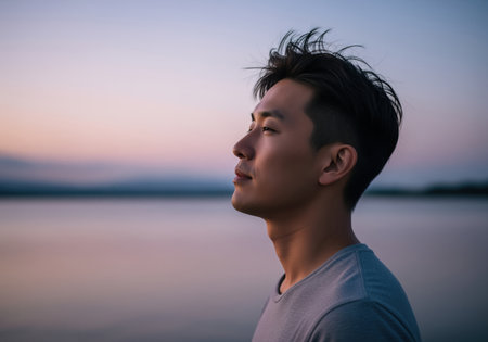 A contemplative east asian man with short, styled dark hair looks upwards with a peaceful expression. this image conveys tranquility and introspection.の素材