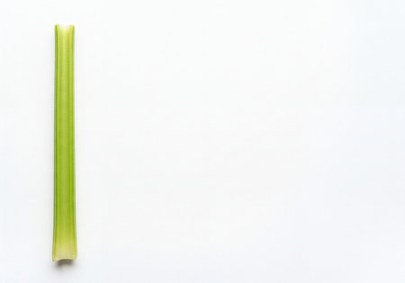 A single, vibrant green celery stalk is freshly harvested and isolated vertically on a crisp white background. Perfect for healthy food concepts, dieting, and clean eating designs.の素材