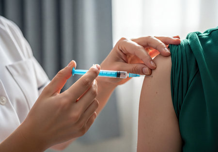A medical professional in a white uniform administers a vaccine injection into a patient arm. this image illustrates healthcare, prevention, and medical treatment.の素材
