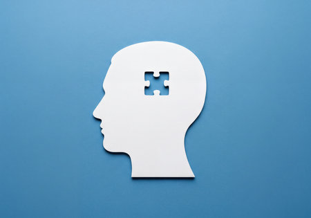 White head silhouette with a puzzle piece cutout on a blue surface, representing the search for ideas, mental block, or missing information. Symbolizes memory, intellect, and cognitive function.の素材
