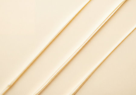 Abstract light yellow creamy texture background featuring smooth diagonal lines, creating an elegant and soft aesthetic perfect for cosmetic or beauty product designs.の素材