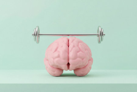 A pink human brain supports a heavy silver metal barbell on a soft pastel mint green background to symbolize intelligence, strong mind, and cognitive power training.の素材