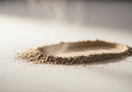 A close up, cinematic view captures fine beige mineral powder settling onto a light surface, forming a delicate ring. this image is ideal for beauty, cosmetics, skincare, and natural ingredient concepts.の素材