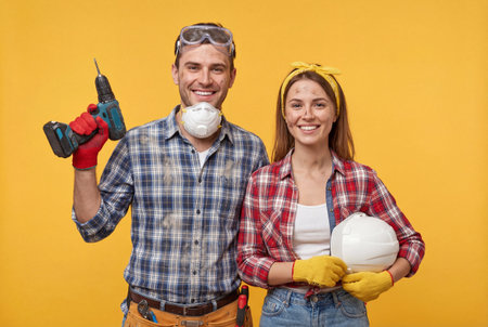 Happy young Caucasian couple standing side-by-side against a vibrant yellow background, smiling and looking directly at the camera, conveying a sense of joy and positivityの素材