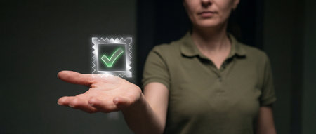 A woman presents a vibrant glowing holographic checkmark in her open left palm against a dark background symbolizing approval or success in a futuristic contextの素材
