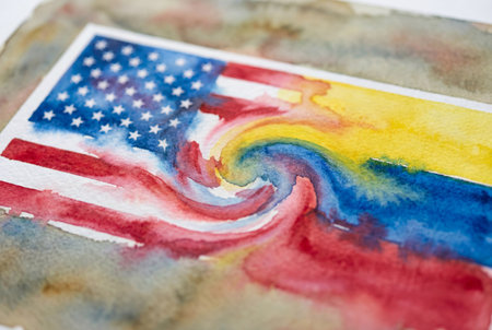 National flags of the united states and venezuela merging in a swirl of colorful watercolor paint on textured paper representing diplomacy and international relations.の素材