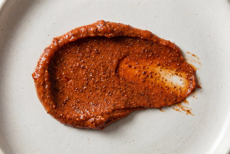 An irregular swatch of rich terracotta cosmetic scrub reveals fine exfoliating particles within its thick, creamy texture, perfect for natural beauty and skincare contentの素材