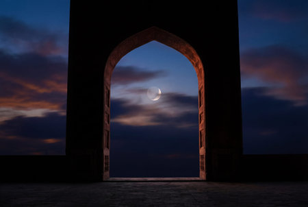 Silhouetted arched mosque entrance frames crescent moon against twilight sky with scattered clouds creating serene night architectural viewの素材