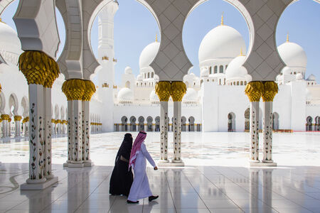 ABU DHABI - MARCH 31, 2013  A muslim man and woman walking at Sheikh Zayed Grand Mosque taken on March 31, 2013 in Abu Dhabi, United Arab Emirates のeditorial素材