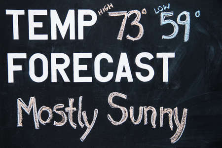 orecast mostly sunny on a chalkboard for a good vacation startの写真素材
