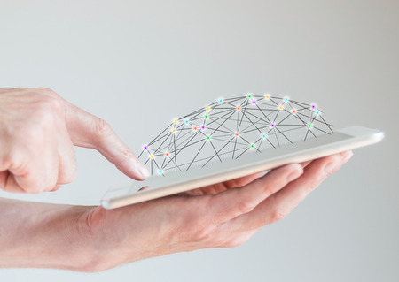 Mobile tablet in male hands with fingers pointing at the display. Concept of computer networks and social networks accessible via the internet and mobile devices.の写真素材