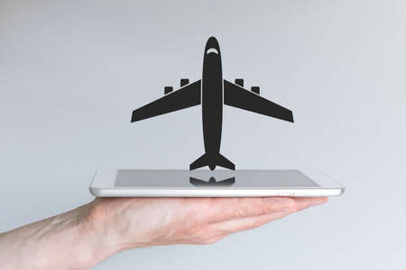 Online flight booking concept with smart phone or tablet. Hand holding modern smart phone or tablet.の写真素材