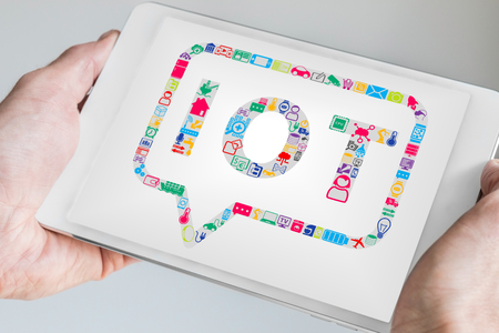 Hand holding mobile device like tablet or smart phone. Internet of Things IOT concept as backgroundの写真素材