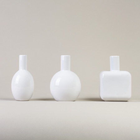 Small white vases set  different shapes on gray background side viewの写真素材
