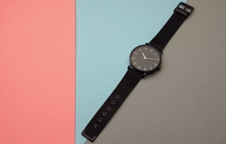 Wrist watch on pastel colors paper background