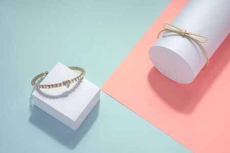 Modern Golden bracelets on light blue and pink backgroundの写真素材