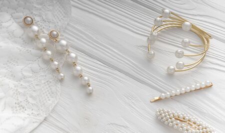 Top view of golden and pearls jewelry on white wooden backgroundの写真素材