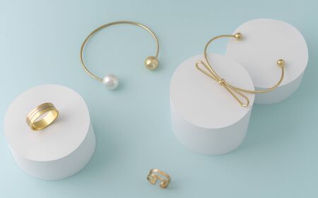 Golden bracelets and rings flat lay on green and white backgroundの写真素材