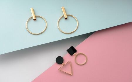 Geometric shapes earrings pair on pastel colors backgroundの写真素材