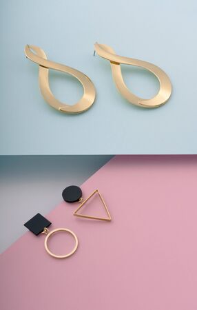 Geometric and infinity shape golden earrings on pastel colors backgroundの写真素材