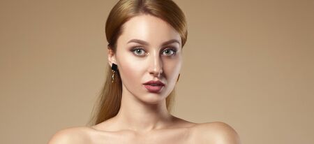 Portrait of pretty Caucasian girl's face on beige color background