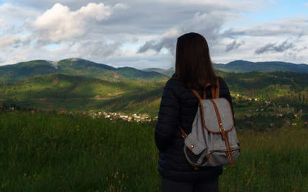 Woman with backpack looking at view of mountains