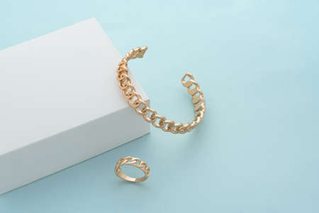 Chain shape cuff bracelet and ring on white box on blue background with copy spaceの写真素材