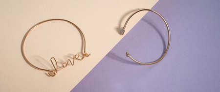 Panoramic shot of love word shape bracelet on pastel colors background