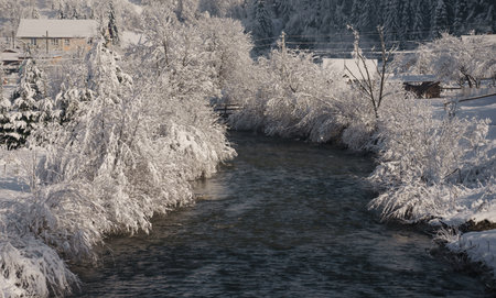 Hidden House on river side in snowy mountain forest in winterの写真素材