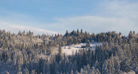 Hidden House on river side in snowy mountain forest in winterの写真素材
