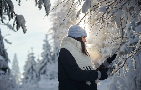 portrait of a woman touching snow on trees with copy spaceの写真素材